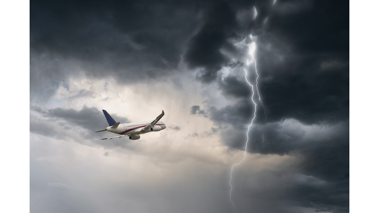 Commercial airplane flying in stormy weather with a lightning - dangerous flight and risk of aircraft accident