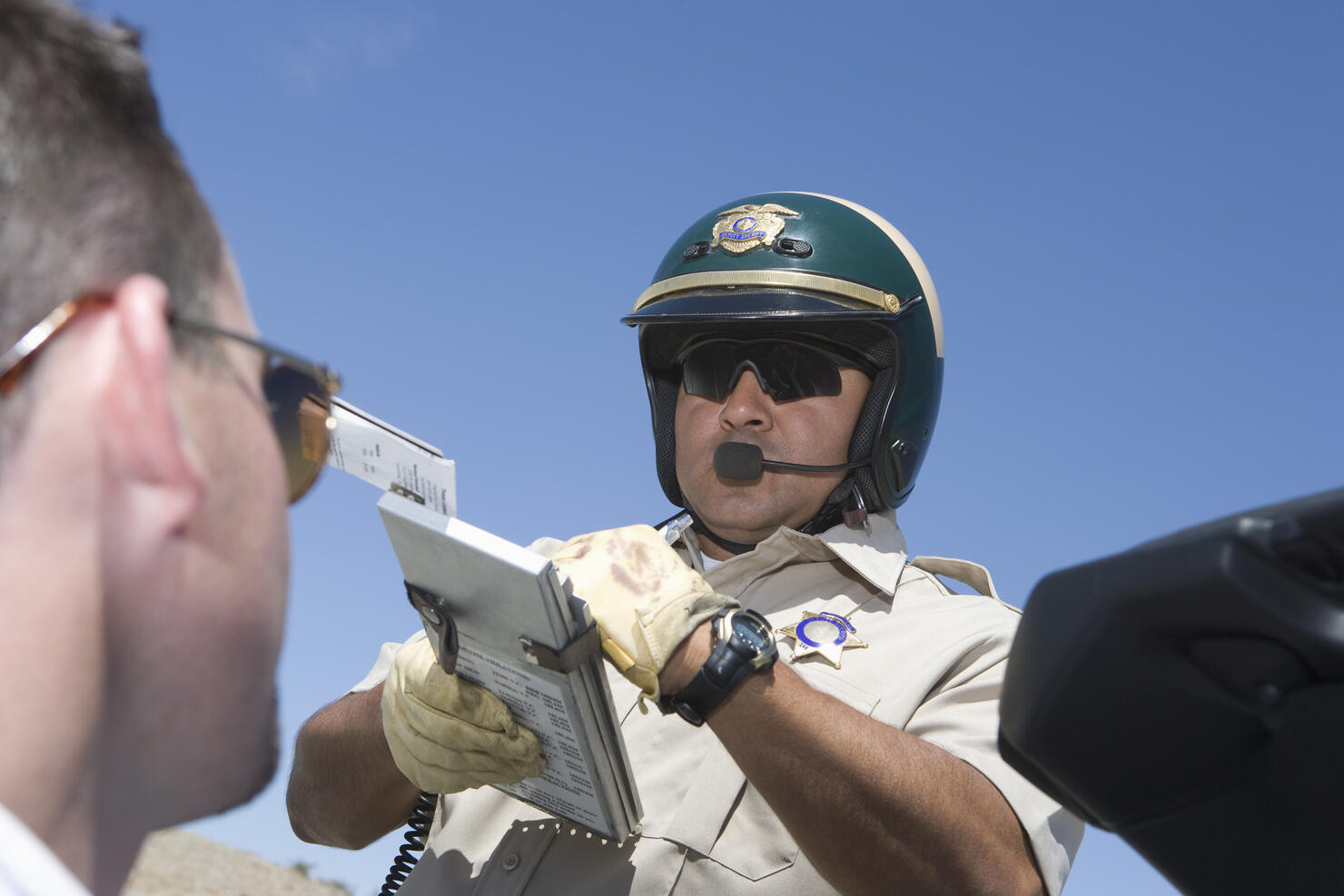 Police man writing man speeding ticket