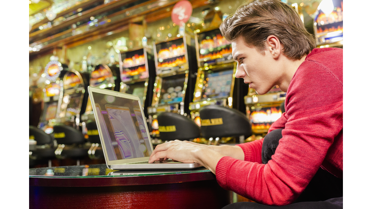 Young man playing poker on his laptop