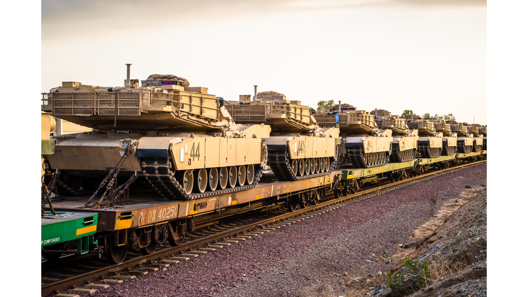 Light Brown Combat Ftrac 120mm Gun Tanks in Transport on Rail Train In Line with Blue Sky for War Defense Artillery