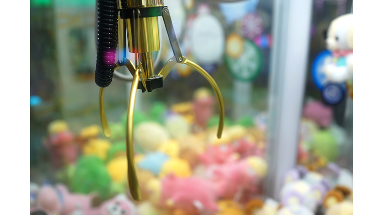 Close up of the doll claw machine of games arcade in shopping mall