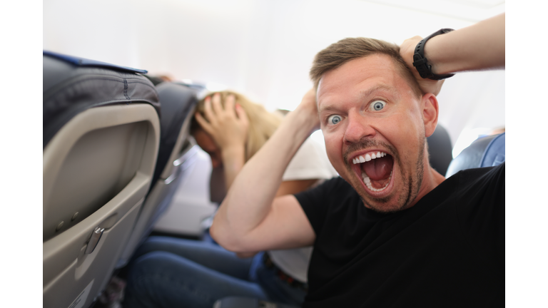 Man flying in airplane and screaming in fear