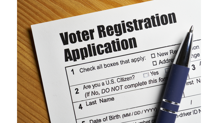 Voter registration application document with hand holding pen