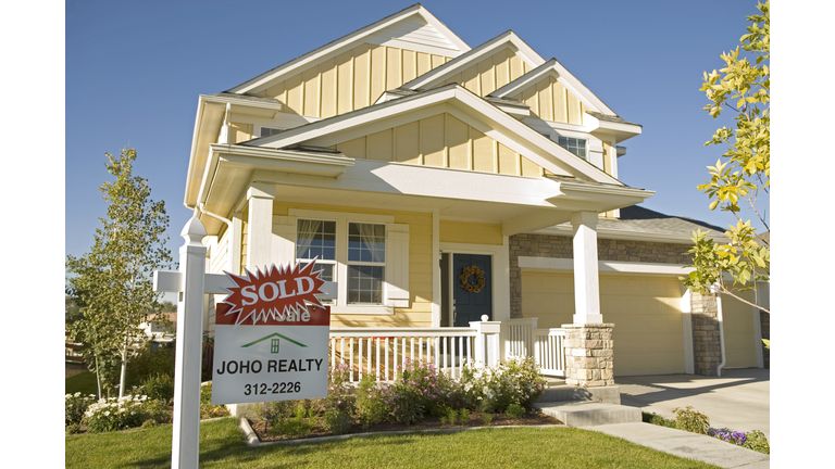 Sold' sign posted in front of house, close-up