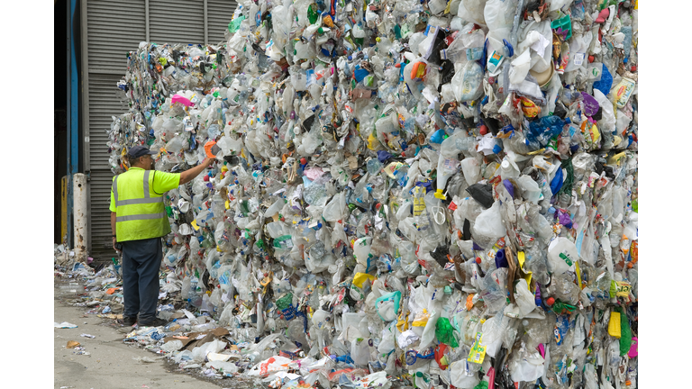 man examines bales of plastic waste bottles