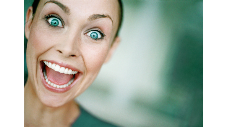 Young woman with eyes and mouth open wide, close-up, portrait