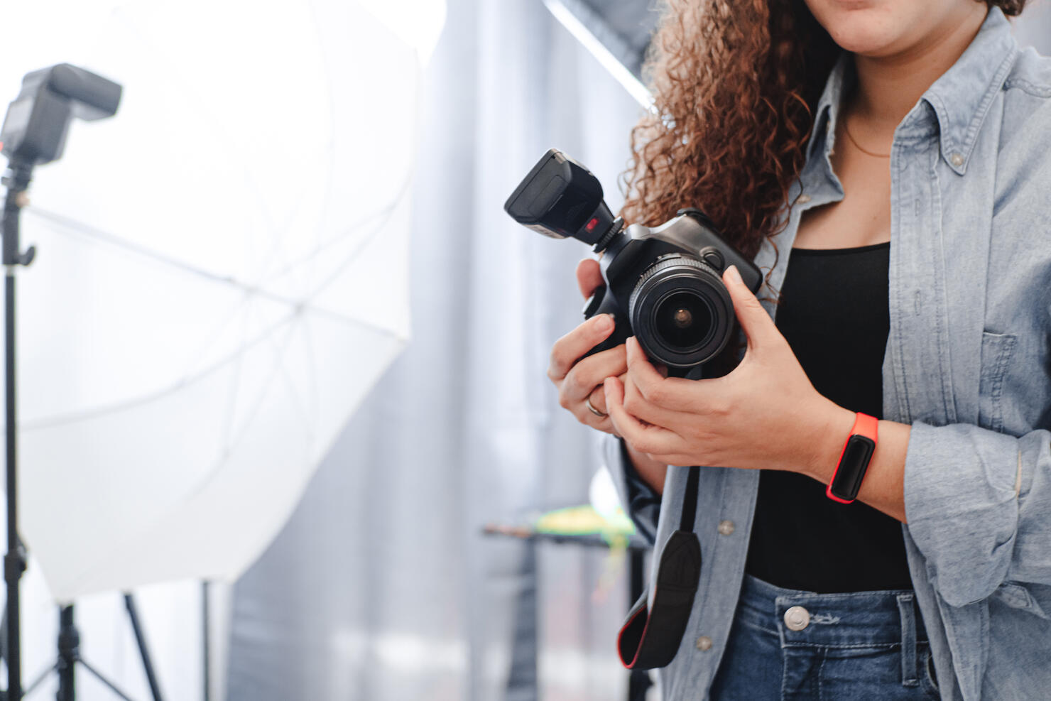 unknown photographer woman holding a professional camera on the studio.