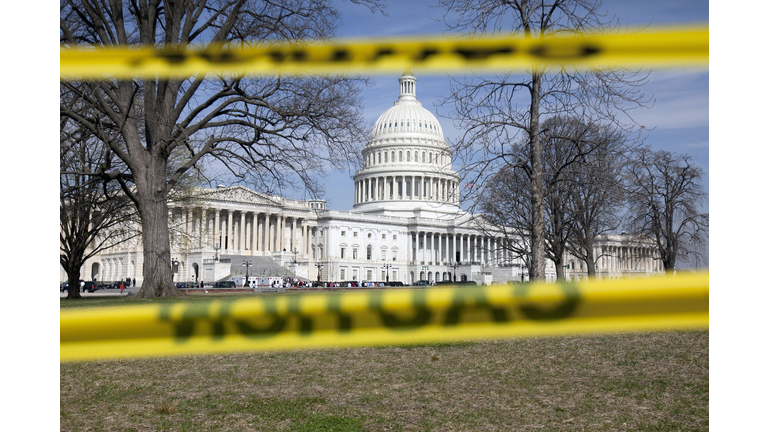 The Capitol building stands behind caution tape