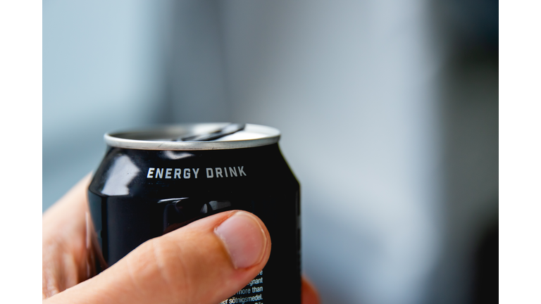 a close up of a hand holding a can of energy drink