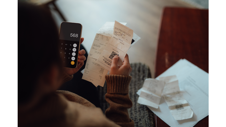 Young woman calculating financial bills at home