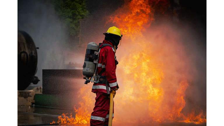 The firefighters are spraying water to contain the internal fire outbreak within the factory.