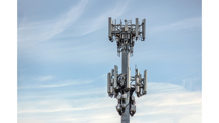 Communications cell tower mobile phone data blue sky clouds