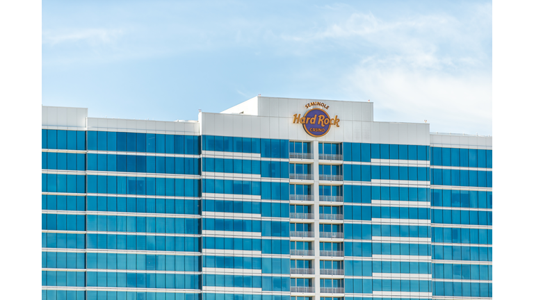Seminole Hard Rock Cafe hotel and casino resort sign for famous restaurant in Florida exterior facade of modern glass building and blue sky