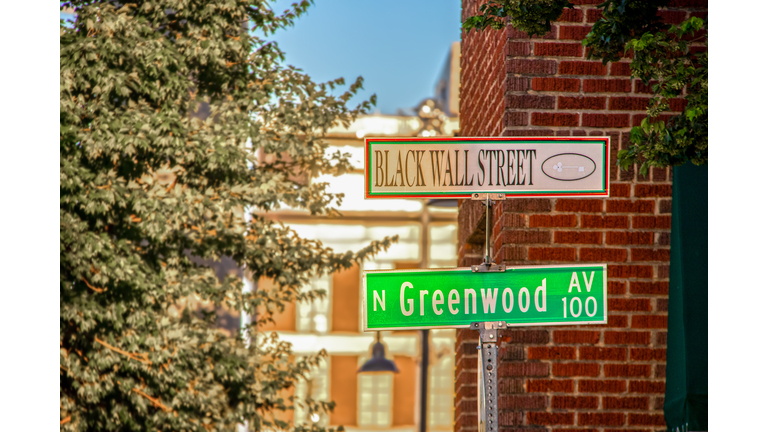 Black Wall Street and N Greenwood Avenue street signs - closeup - in Tulsa Oklahoma with bokeh background