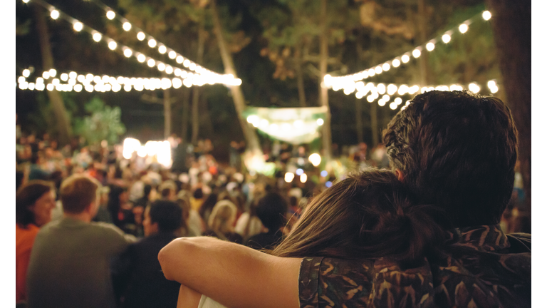 Young couple embracing at night music festival