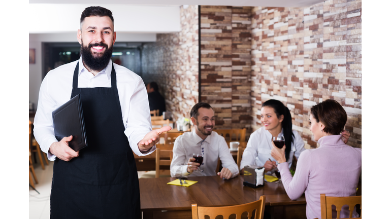 Waiter welcoming guests in restaurant