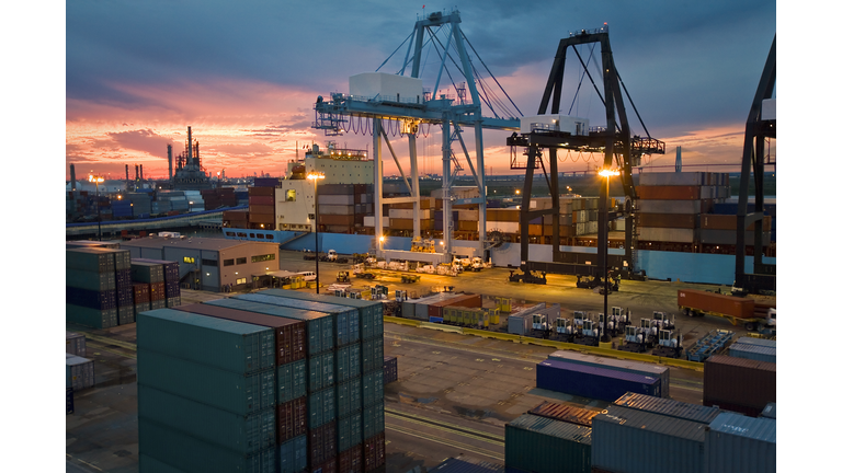 Cargo container and cranes on docks at dusk