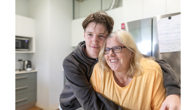 Mother and teenage son hugging