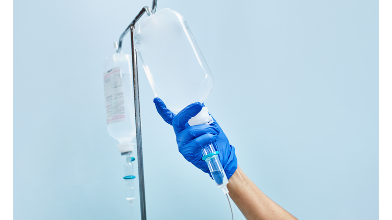 nurse's hand preparing an intravenous drip