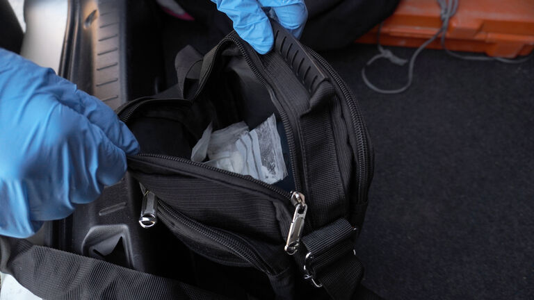 black bag with pechetics with white powder inside