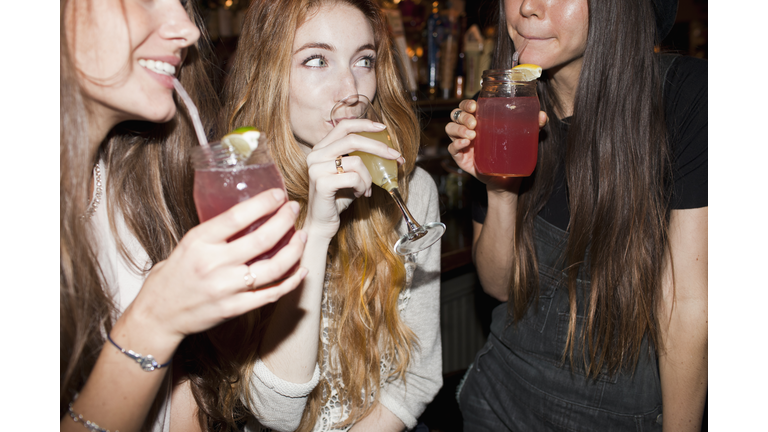Happy young friends enjoying drinks at a bar