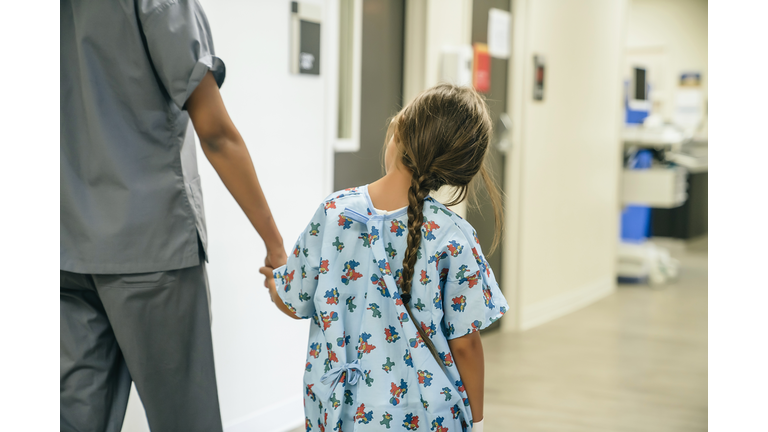 Nurse holding hands with girl in hospital