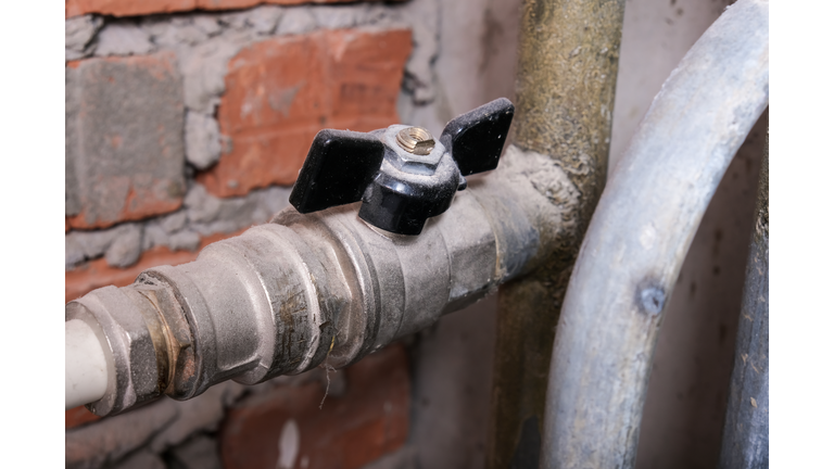 Black brass ball shut-off valves on water supply pipeline in the house, plumbing and construction concept