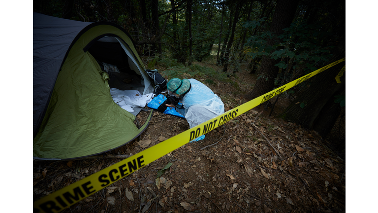 Forensics researcher photographing a blood  at a murder scene