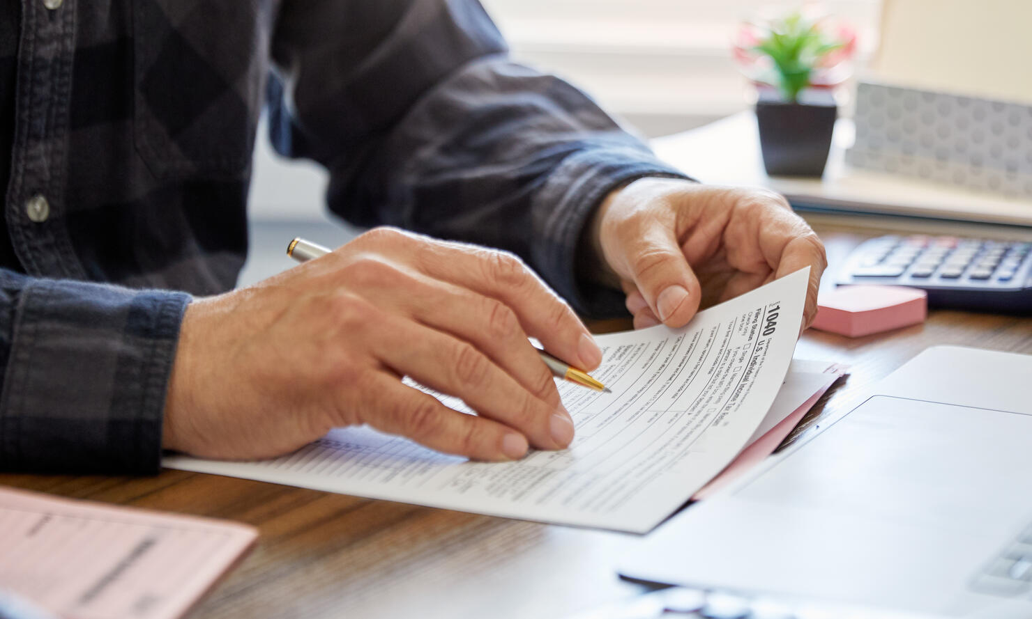 Close-up of a man holding a tax form, working from home