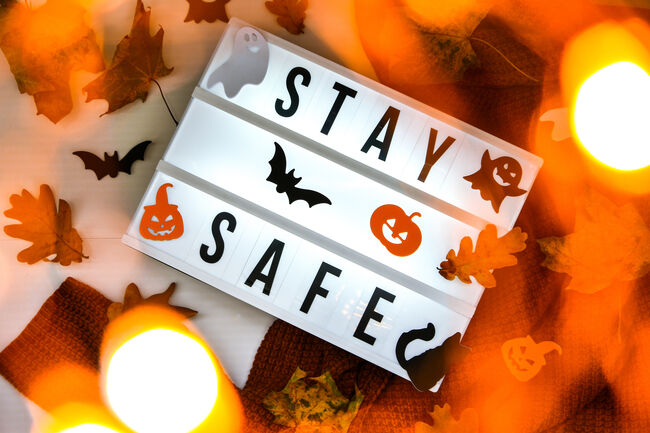 Stay safe. Text in white light box, with a background of sweater, dried leaves halloween autumn decoration. Coronavirus devices. Social distancing. Protection against pandemics