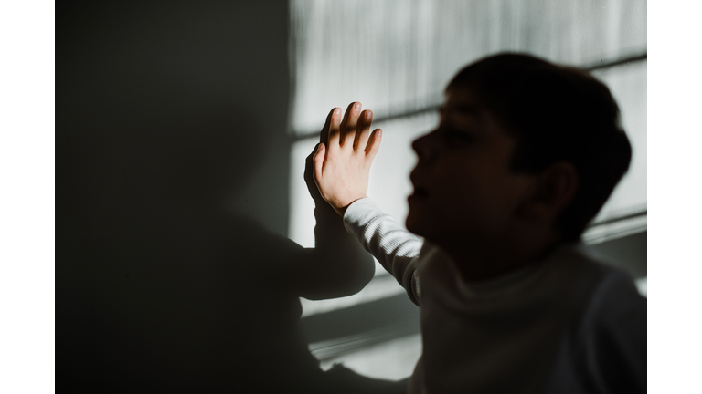 Young boy with autism hand in focus face silhouette