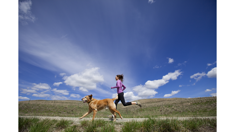 A woman and her dog jogging.