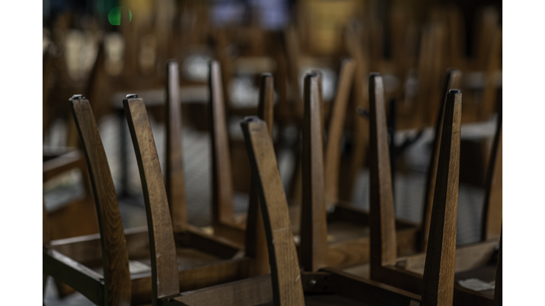 Closed restaurant chairs turned over on tables