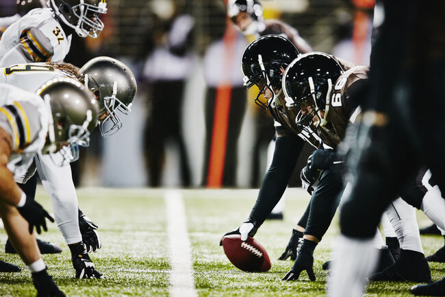 Football teams on line of scrimmage in stadium