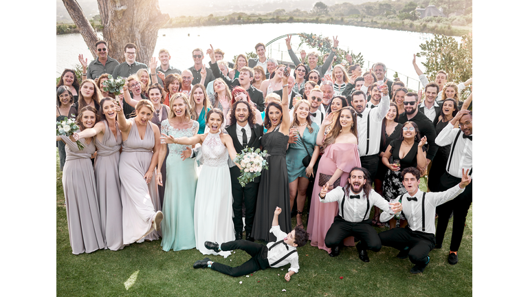 Wedding portrait and bridal party celebrate happy day of love and commitment together with joy. Married couple pose for excited and cheerful ceremony people photograph with friends and family.