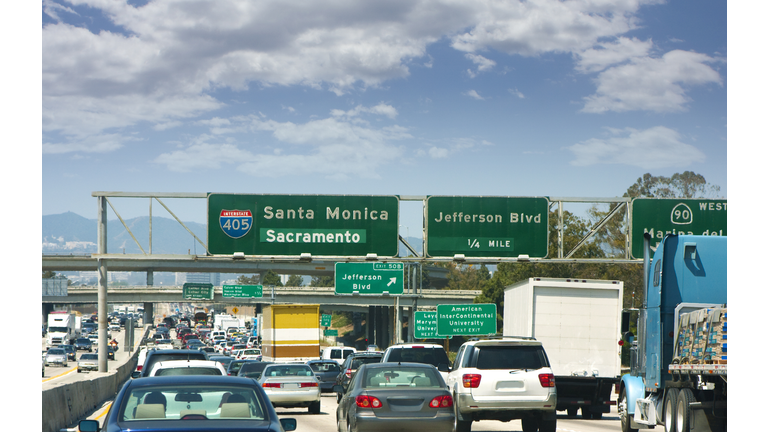 Traffic and street signs on an LA freeway