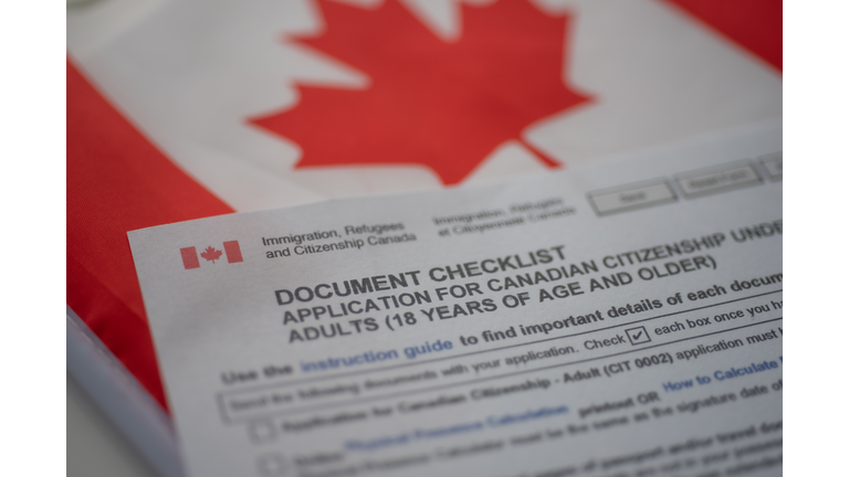 Document check list application for canadian citizenship next to Canadian flag, close up view.