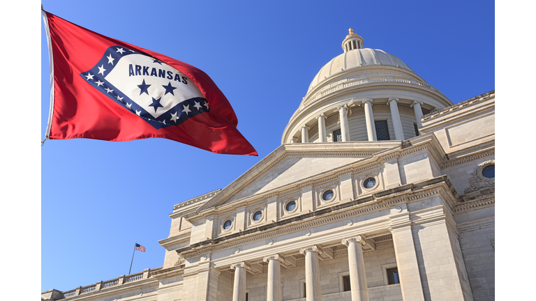 Arkansas flag flying high beside the State Capitol Building