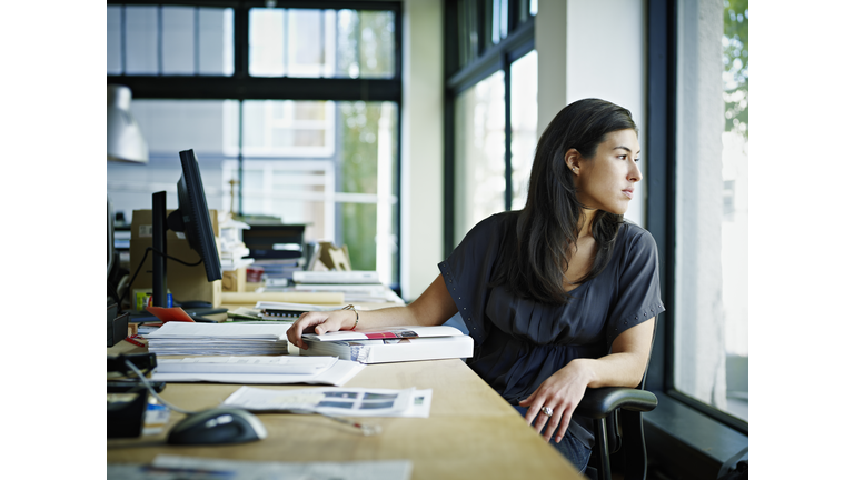 Businesswoman sitting in office looking out