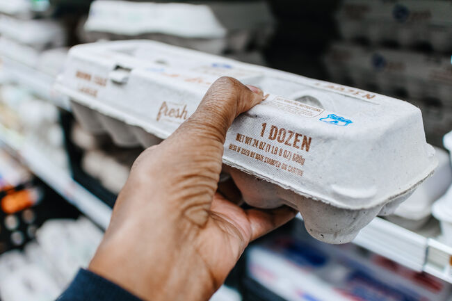 Woman Picks Up Carton of Eggs at Supermarket