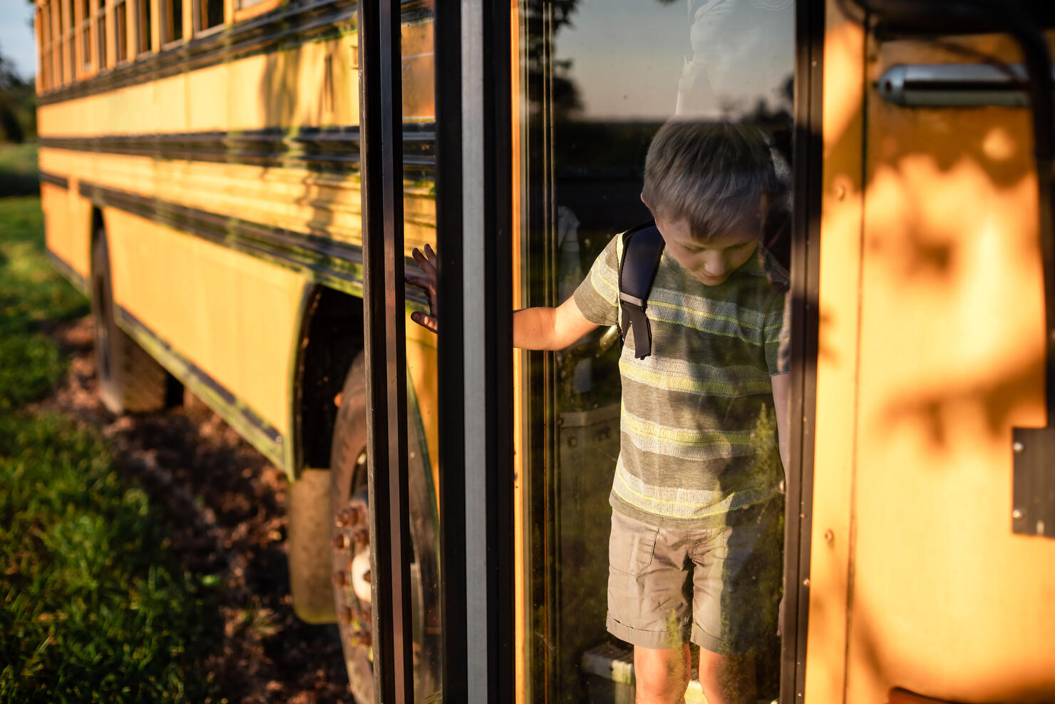 Child getting off the bus at bus stop after school
