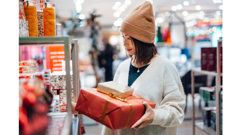 Young woman shopping Christmas gifts in department store