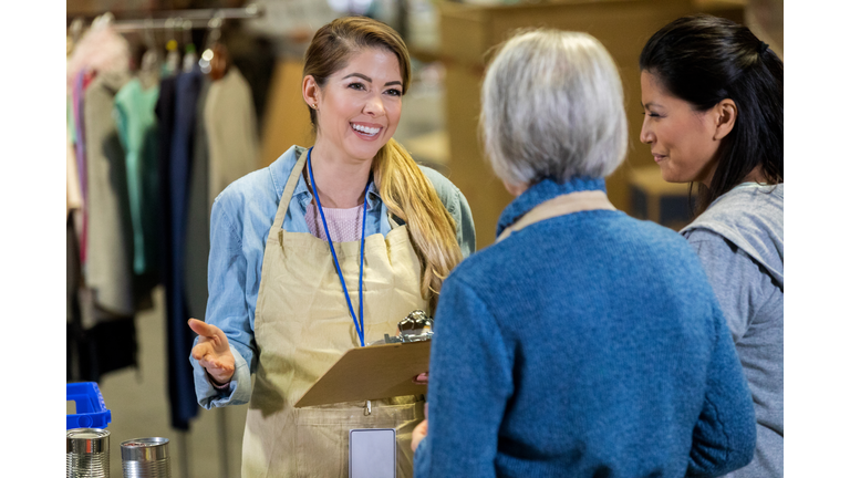 Cheerful food bank manager talks with volunteers