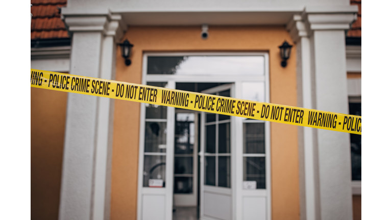 Yellow crime scene tape in front of a house