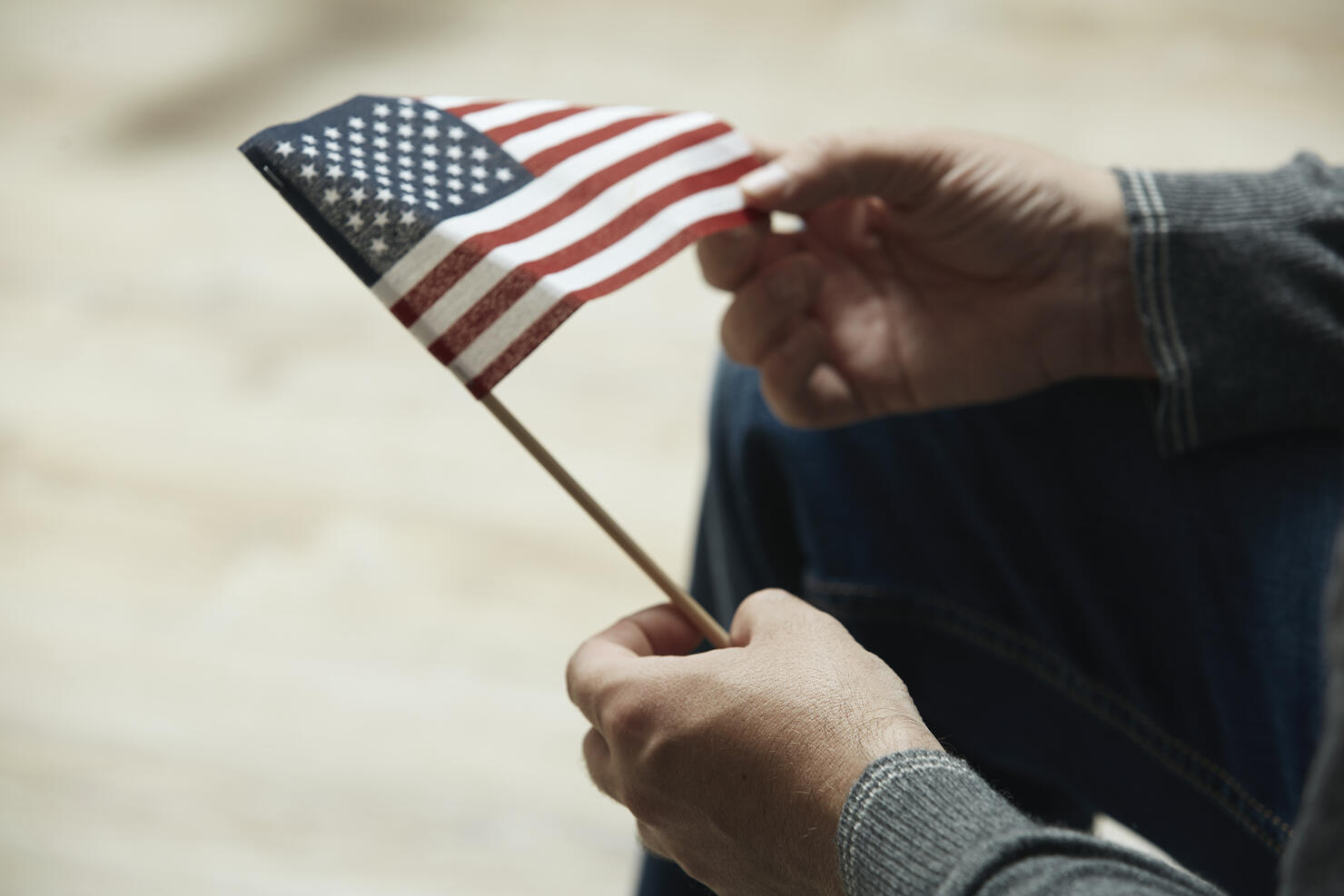 Midsection of man holding small American Flag