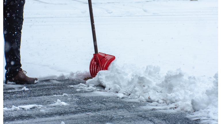 Man cleaning the sidewalk covered in snow