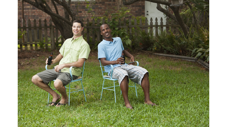 Men relaxing in back yard with beer