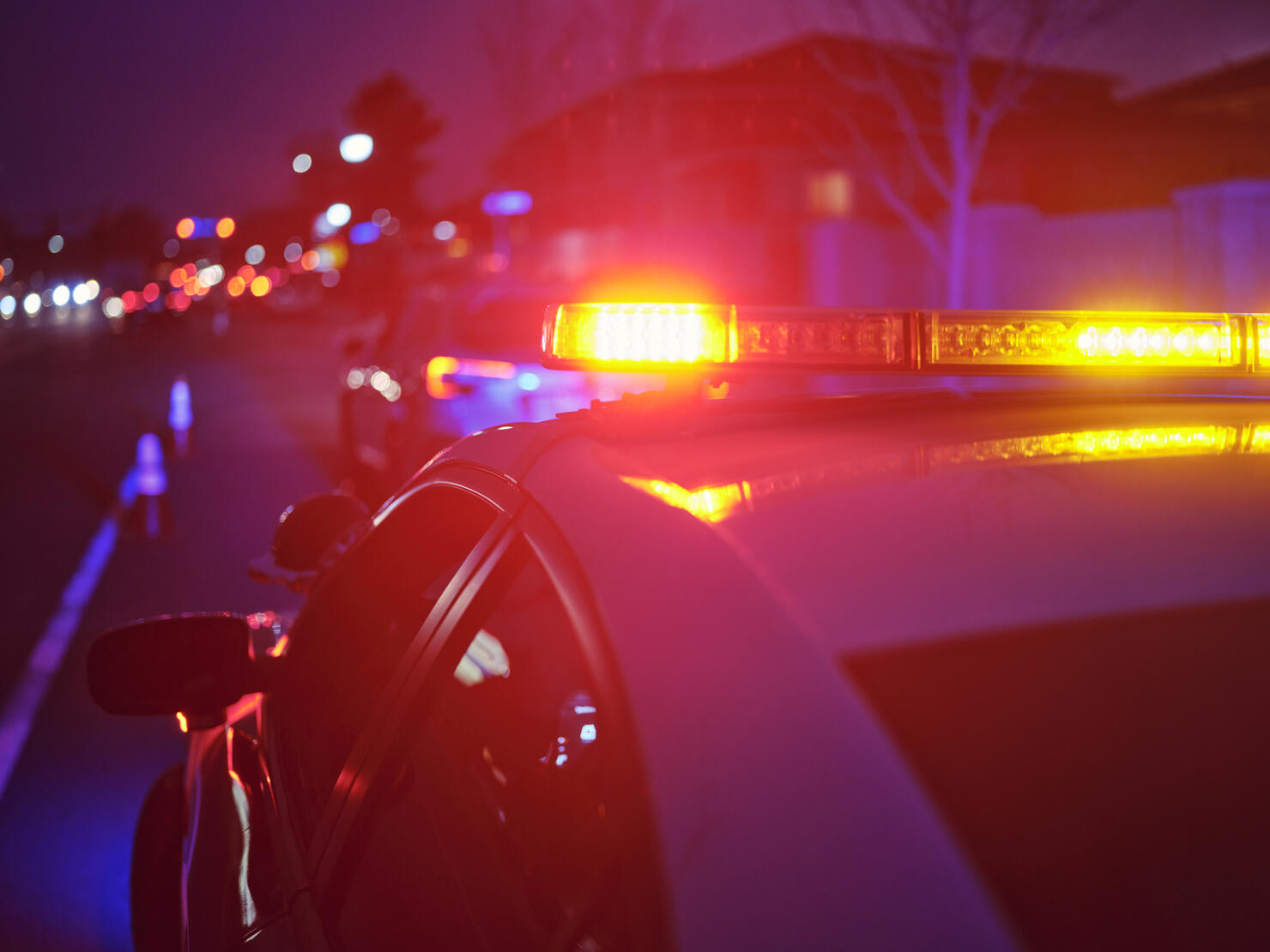 Police Car Stopped on a Road at Night with Emergency Lights
