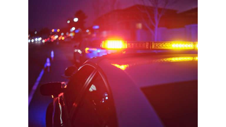 Police Car Stopped on a Road at Night with Emergency Lights