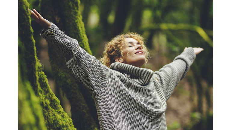 Happiness and nature wellbeing healthy people. One woman smile and enjoy freedom in outdoor leisure activity. Celebrating planet earth. Travel nature destination. Outstretching arms to breathe oxygen